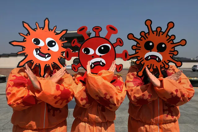 South Korean environmental activists wearing masks symbolizing the coronavirus attend a prevention campaign as South Koreans take measures to protect themselves against the spread of coronavirus (COVID-19) on March 30, 2020 in Seoul, South Korea. South Korea has called for expanded public participation in social distancing, as the country witnesses a wave of community spread and imported infections leading to a resurgence in new cases of COVID-19. According to the Korea Center for Disease Control and Prevention on Monday, 78 new cases were reported. The total number of infections in the nation tallies at 9,661. (Photo by Chung Sung-Jun/Getty Images)