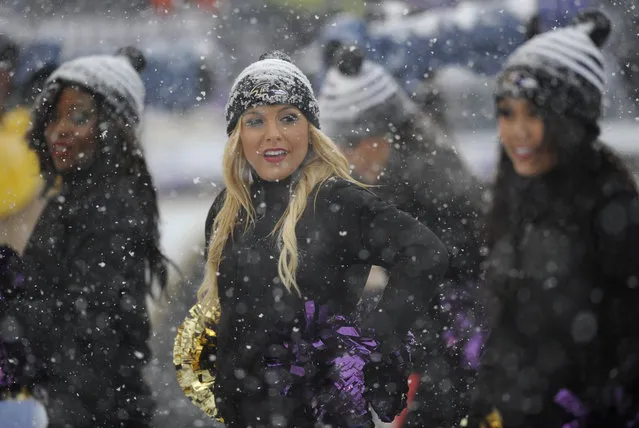Baltimore Ravens cheerleaders stand on the sideline as snow falls in the first half of an NFL football game against the Minnesota Vikings, Sunday, December 8, 2013, in Baltimore. (Photo by Nick Wass/AP Photo)