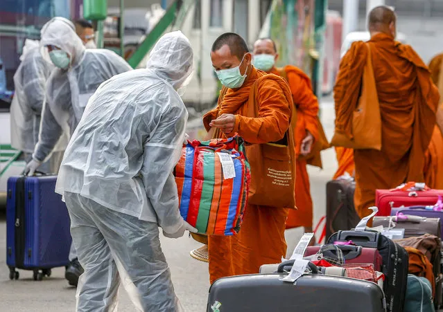A soldier wearing a protective suit helps a Buddhist monk to carry his luggage bag at Don Mueang International Airport in Bangkok. Thailand has so far reported 2,854 cases of COVID-19 coronavirus with most of the cases reported in the Capital city of Bangkok. (Photo by Chaiwat Subprasom/EPA/EFE/Rex Features/Shutterstock)