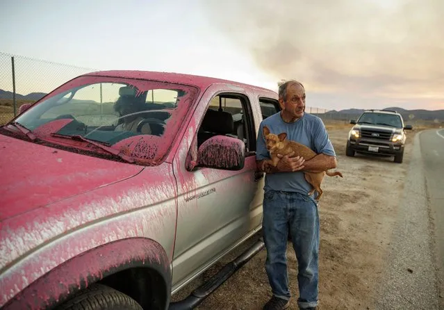 Rick Fitzpatrick holds a dog after evacuating from the Fairview Fire Monday, September 5, 2022, near Hemet, Calif. (Photo by Ethan Swope/AP Photo)