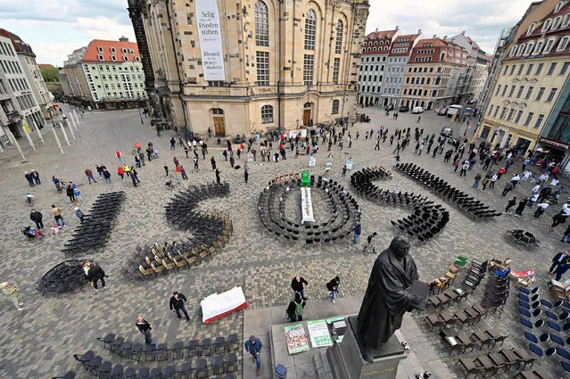 Empty chairs arranged to display “SOS” are placed at the Neumarkt square to call attention to the difficult situation of hotel and restaurant owners, as the spread of the coronavirus disease (COVID-19) continues in Dresden, Germany, May 1, 2020. (Photo by Matthias Rietschel/Reuters)
