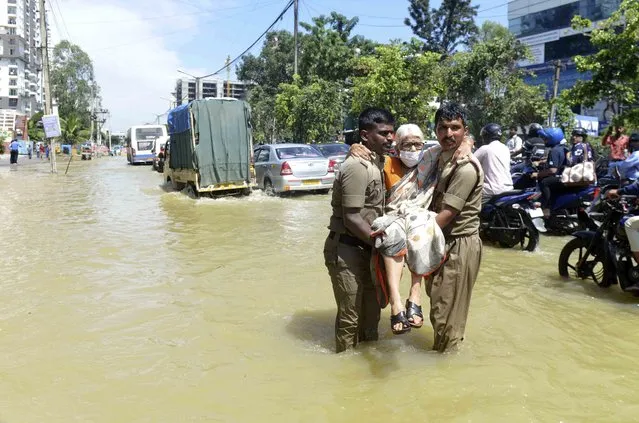 Firefighters help an elderly woman move to a safer area after heavy rainfall in Bangalore, India, Monday, September 5, 2022. Life for many in the southern Indian city of Bengaluru was disrupted on Tuesday after two days of torrential rains set off long traffic snarls, widespread power cuts and heavy floods that swept into homes and submerged roads. (Photo by Kashif Masood/AP Photo)
