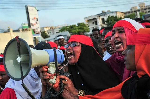 People chant slogans as they protest against the deadly bomb attack in Mogadishu on October 15, 2017, after a truck bomb exploded outside of the Safari Hotel on a busy road junction, levelling buildings and leaving many vehicles in flames. The death toll from a massive weekend truck bomb in a busy shopping district of Mogadishu surged to at least 137, police said today, warning it could rise further after one of the worst-ever attacks to hit war-torn Somalia. (Photo by Mohamed Abdiwahab/AFP Photo)