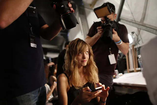 Fashion model Yulia Musieichuk of Kiev, Ukraine, reacts as she is photographed from multiple angles while having her toenails painted backstage before the Rebecca Minkoff Spring 2015 collection show Friday, September 5, 2014, during Fashion Week, in New York. Musieichuk, 22, who was scouted in her native Ukraine at age 16, has a mother, father, sister and nephew back home. (Photo by Jason DeCrow/AP Photo)