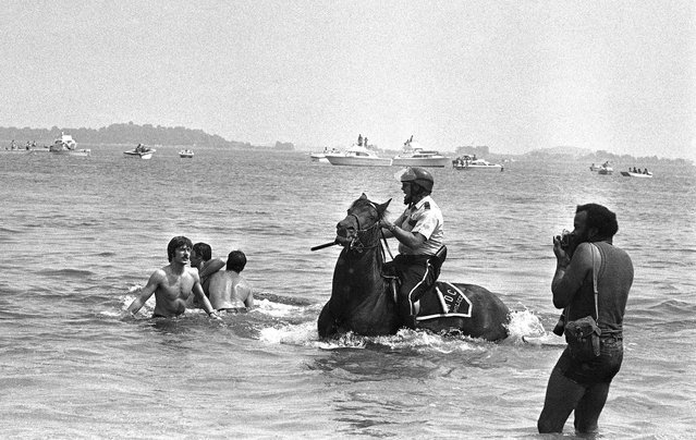 A mounted Metropolitan District Commission policeman pursues white bathing demonstrators who attempted to invade area of black bathers, August 10, 1975 at Carson Beach in South Boston. Black and white bathers threw rocks and bricks at one another at times. About 500 blacks were at the beach in predominantly white South Boston in a response to a request by black leaders who said they wanted to ìreassert the rights of all Boston residents to use all public facilities.î (Photo by Peter Bregg/AP Photo)