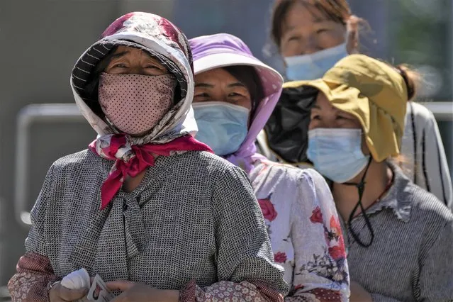 Women wearing face masks wait in line to get their routine COVID-19 throat swabs at a coronavirus testing site in Beijing, Tuesday, September 20, 2022. (Photo by Andy Wong/AP Photo)