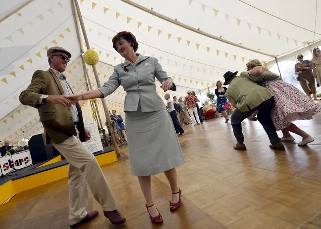 Visitors and car enthusiasts dance at the Goodwood Revival historic motor racing festival in Goodwood, near Chichester in south England, Britain, September 11, 2015. (Photo by Toby Melville/Reuters)