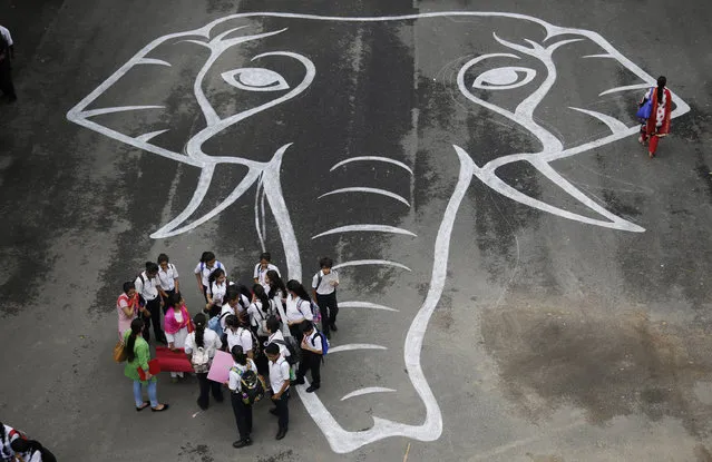Indian school children talk next to the outline of an elephant head drawn on the ground during an event to observe World Elephant Day in New Delhi, India, Friday, August 12, 2016. (Photo by Altaf Qadri/AP Photo)