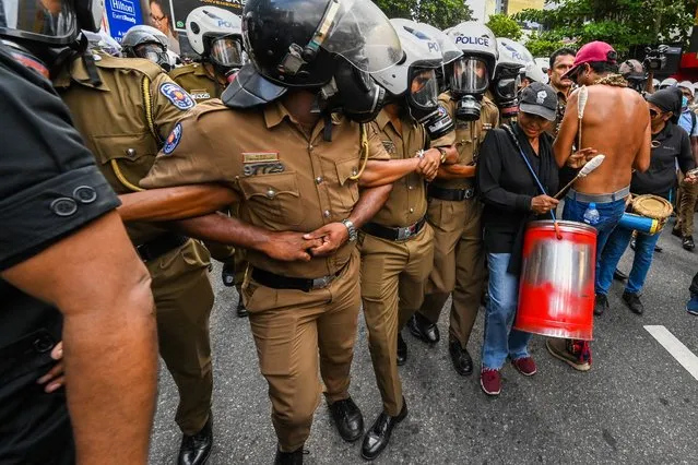 Policemen try to block Sri Lankan university students during a demonstration in Colombo on August 18, 2022. (Photo by Ishara S. Kodikara/AFP Photo)
