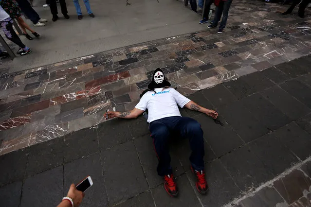 Mexican wrestler known as Parka rests on the floor during the annual pilgrimage to the Basilica of Our Lady Guadalupe in Mexico City, Mexico August 25, 2016. (Photo by Carlos Jasso/Reuters)