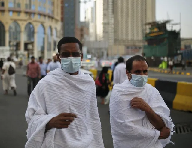 Muslim pilgrims wear protective masks as they walk on a road in the holy city of Mecca ahead of the annual haj pilgrimage September 21, 2015. (Photo by Ahmad Masood/Reuters)