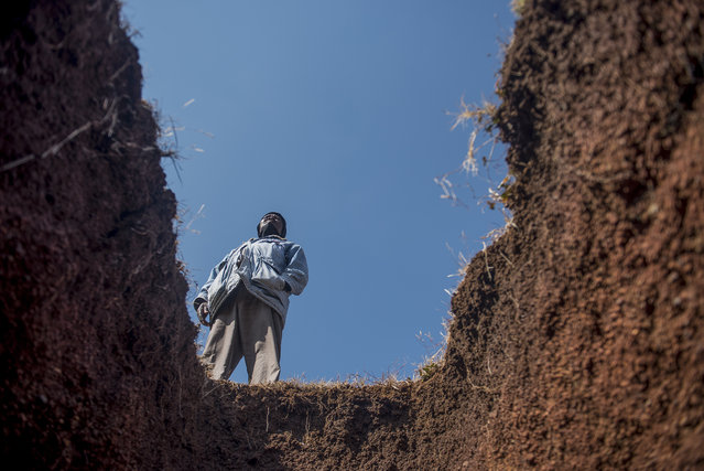 A worker stands next to a freshly-dug grave at the Honingnestkrans Cemetery, North of Pretoria, South Africa, Thursday, July 9, 2020. The Africa Centers for Disease Control and Prevention says the coronavirus pandemic on the continent is reaching “full speed” after cases surpassed a half-million and a South African official said a single province is preparing 1.5 million grave. (Photo by Shiraaz Mohamed/AP Photo)