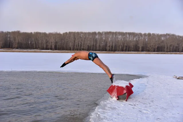 A winter swimmer dives into the icy water of Songhua river in Songyuan, Jilin province, China December 10, 2017. (Photo by Reuters/China Stringer Network)