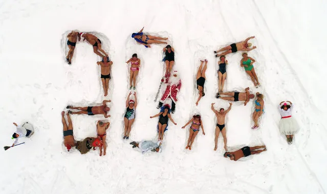 An aerial view shows people dressed as Father Frost, the Russian equivalent of Santa Claus, and Snow Maiden with members of the Cryophile winter swimming club forming with their bodies a 2018 sign on the bank of the Yenisei River to mark the upcoming New Year and Christmas season in the Siberian city of Krasnoyarsk, Russia December 24, 2017. (Photo by Ilya Naymushin/Reuters)