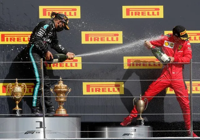 Mercedes driver Lewis Hamilton of Britain, left, sprays champagne with third placed Ferrari driver Charles Leclerc of Monaco at the podium after winning the British Formula One Grand Prix at the Silverstone racetrack, Silverstone, England, Sunday, August 2, 2020. (Photo by Frank Augstein/AP Photo/Pool)