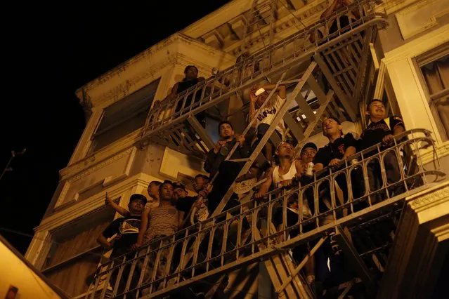 People watch a street celebration from a balcony in San Francisco, California October 29, 2014. (Photo by Stephen Lam/Reuters)