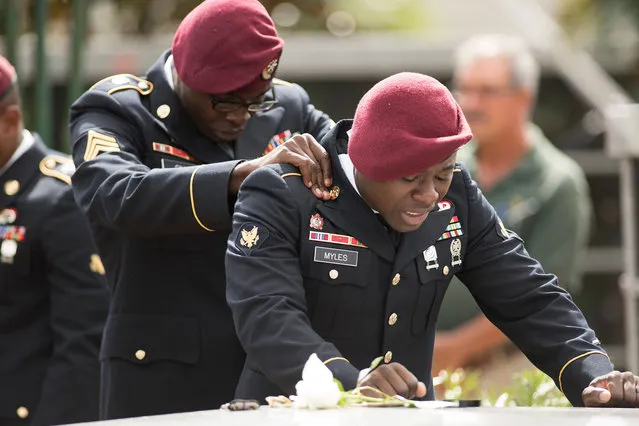 Members of the 3rd Special Forces Group, 2nd battalion, comfort each other as they say their las goodbyes to US Army Sgt. La David Johnson at the Memorial Gardens East cemetery on October 21, 2017 in Hollywood, Florida. Sgt. Johnson and three other US soldiers were killed in an ambush in Niger on October 4. (Photo by Gaston De Cardenas/AFP Photo)