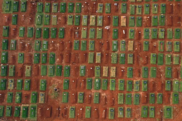 This aerial picture taken on August 10, 2020 shows a graveyard for victims of the COVID-19 coronavirus at the Pondok Ranggon cemetery in Jakarta. The country of nearly 270 million is among the worst hit in Asia by the pandemic, with cases in all its 34 provinces, including the remote Maluku island and easternmost Papua. (Photo by Adek Berry/AFP Photo)