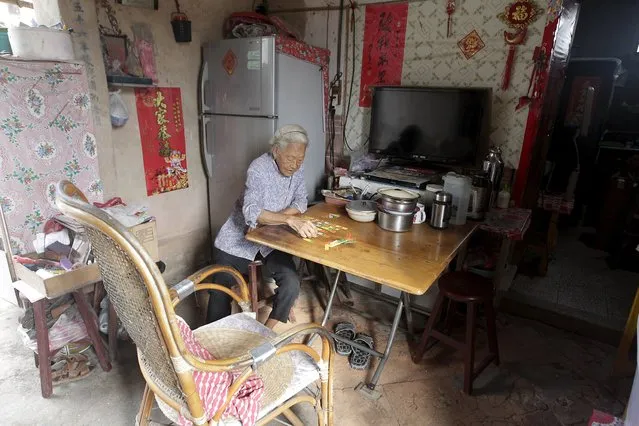 An elderly woman plays cards in her kitchen in the village of Guningtou in Kinmen, Taiwan, September 7, 2015. (Photo by Pichi Chuang/Reuters)