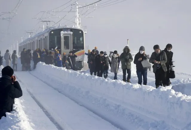 Passengers take shelter from a stranded train in Sanjo, Niigata prefecture, north of Tokyo Friday, January 12, 2018. A Japanese railway official says about 430 people were stuck on the train overnight because of heavy snow that blanketed much of the country’s Japan Sea coast. (Photo by Suo Takekuma/Kyodo News via AP Photo)