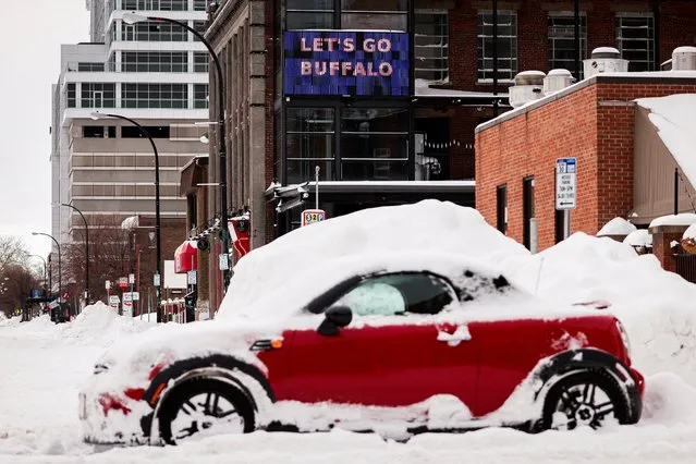 A “let’s go Buffalo” sign is seen behind an abandoned car on the road following a winter storm in Buffalo, New York, U.S., December 27, 2022. (Photo by Lindsay DeDario/Reuters)