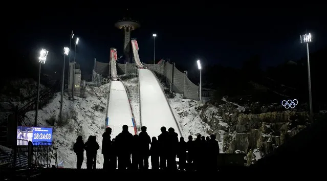 People wait for the start of practice for the men's ski jumping competition in the 2018 Winter Olympics at the Alpensia Ski Jumping Center in Pyeongchang, South Korea, Wednesday, February 7, 2018. (Photo by Charlie Riedel/AP Photo)