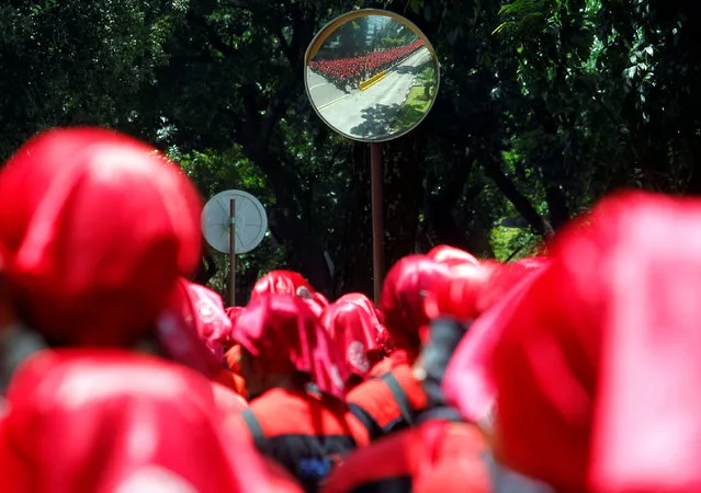 Indonesian union workers protesting against a government tax amnesty are reflected in a traffic mirror as they march towards the presidential palace in Jakarta, Indonesia September 29, 2016. (Photo by Iqro Rinaldi/Reuters)