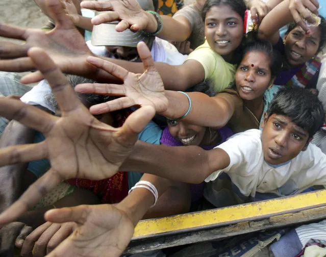 Tsunami survivors rush for clothes and food donated by volunteer organisations in Cuddalore, south of the Indian city of Madras in this December 29, 2004 file photo. (Photo by Arko Datta/Reuters)