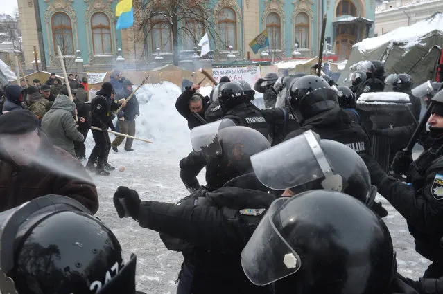 Policemen clash with supporters of former Georgian President Mikhael Saakashvili based in a tents camp in front of the Ukrainian parliament in Kiev on February 27, 2018. 14 policemen were wounded as a result of the clash after activists unexpected tried to burn tires, threw stones and Molotov cocktails. Nine activists were detained by police. Former Georgian president Mikheil Saakashvili on February 21 was banned from entering Ukraine for three years after Kiev deported the opposition leader earlier this month. (Photo by AFP Photo/Stringer)