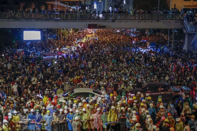 Pro-democracy activists march to the Government House, prime minister's office during a protest march in Bangkok, Thailand, Wednesday, October 21, 2020. Thailand's prime minister on Wednesday pleaded with his countrymen to resolve their political differences through Parliament, as student-led protests seeking to bring his government down continued for an eighth straight day. (Photo by Sakchai Lalit/AP Photo)