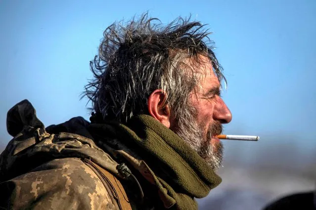 A Ukrainian service member smokes near a frontline, amid Russia's attack on Ukraine, in Donetsk region, Ukraine on February 8, 2023. (Photo by Yevhenii Zavhorodnii/Reuters)