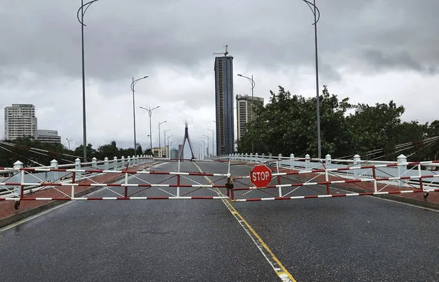 An empty street is barricaded ahead of Typhoon Molave in Da Nang, Vietnam Wednesday, October 28, 2020. Typhoon Malove sank a few fishing boats as it approached Vietnam's south central coast on Wednesday morning. (Photo by Vo Van Dung/VNA via AP Photo)