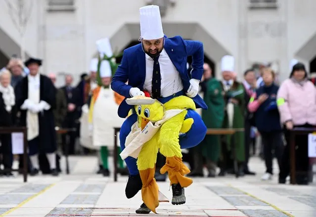 Worker from one of the City Company professions wears a costume as he takes part in the Shrove Tuesday Inter-Livery Pancake Race at the Guildhall in the City of London, in London, Britain on February 21, 2023. (Photo by Toby Melville/Reuters)