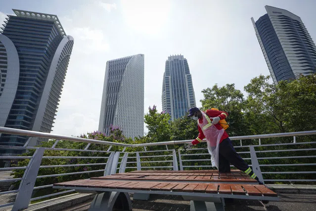 City hall workers spray disinfectant in Putrajaya, Malaysia, on Monday, October 19, 2020. Malaysia restrict movements in its biggest city Kuala Lumpur, neighboring Selangor state and the administrative capital of Putrajaya from Wednesday in an attempt to curb a sharp rise in coronavirus cases. (Photo by Vincent Thian/AP Photo)