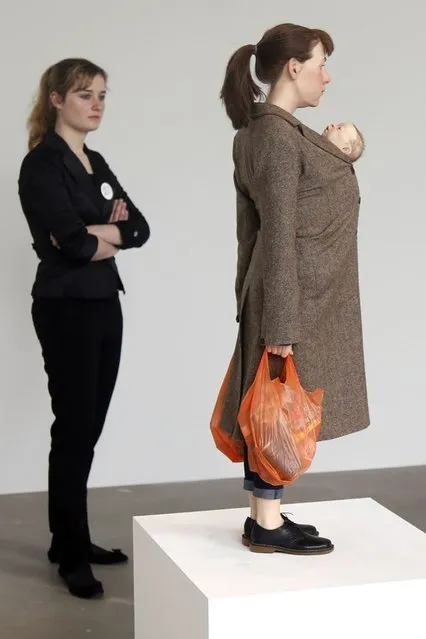 A visitor looks at a sculpture entitled “Woman with Shopping, 2013” by artist Ron Mueck during the press day for his exhibition at the Fondation Cartier pour l'art contemporain in Paris April 15, 2013. (Photo by Charles Platiau/Reuters)