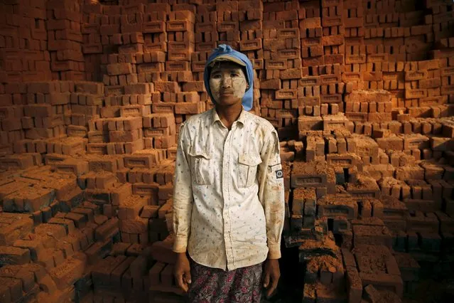 A woman stands while working in a brick factory at the outskirts of Yangon November 4, 2015. (Photo by Jorge Silva/Reuters)