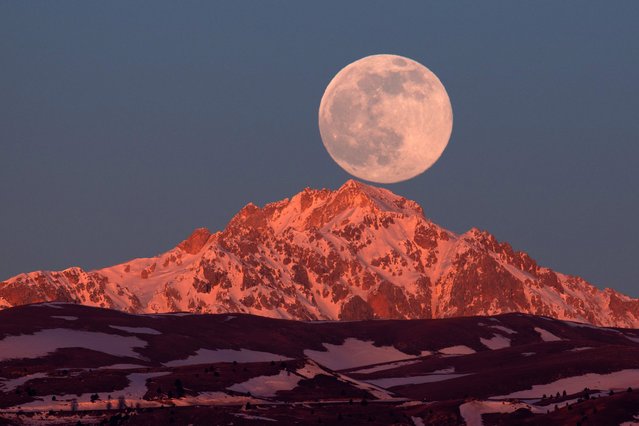 Full moon sets behind Monte Prena in Gran Sasso d'Italia National Park on January, 2022. First full moon of the year is the Wolf moon according to native north Americans. (Photo by Lorenzo Di Cola/NurPhoto via Getty Images)