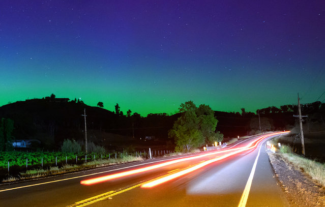 Northern lights or aurora borealis illuminate the night sky along a highway north of San Francisco in Middletown, California on May 11, 2024. The most powerful solar storm in more than two decades struck Earth, triggering spectacular celestial light shows from Tasmania to Britain – and threatening possible disruptions to satellites and power grids as it persists into the weekend. (Photo by Josh Edelson/AFP Photo)