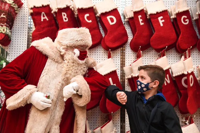  Santa Claus greets Jaythan Corbacho with an elbow bump during the Selfridges 2020 Christmas Shop “Once upon a Christmas” photocall at Selfridges, Oxford Street on October 12, 2020 in London, England. (Photo by Eamonn M. McCormack/Getty Images)