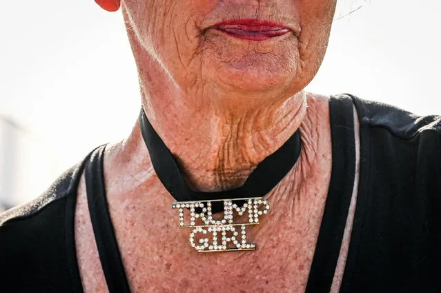 Paula Magnuson, a supporter of former US President Donald Trump, wears a necklace announcing: Trump Girl, near the Mar-a-Lago Club in Palm Beach, Florida, on April 2, 2023. Trump is expected to surrender to the authorities in New York on April 4, 2023 to face charges over a hush-money payment to p*rn star Stormy Daniels. (Photo by Giorgio Viera/AFP Photo)