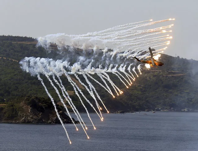 A Turkish army helicopter in action after an amphibious landing during EFES 2018 drills in Seferihisar in Aegean Sea near Izmir, Turkey, Thursday, May 10, 2018. Turkey shows off its military hardware in the EFES 2018 drill. (Photo by Emre Tazegul/AP Photo)