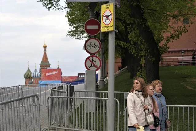 People walk past a sign “No fly zone” at the empty Red Square closed for Victory Parade preparation, next to the Moscow Kremlin, in Moscow, Russia, Wednesday, May 3, 2023. Russian authorities have accused Ukraine of attempting to attack the Kremlin with two drones overnight. The Kremlin on Wednesday decried the alleged attack attempt as a “terrorist act” and said Russian military and security forces disabled the drones before they could strike. (Photo by Alexander Zemlianichenko/AP Photo)