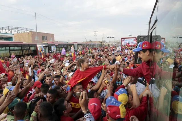 Venezuela's President Nicolas Maduro greets supporters from a bus during the launch ceremony of a new bus route in Maracaibo, in the state of Zulia, in this handout picture provided by Miraflores Palace on November 28, 2015. (Photo by Reuters/Miraflores Palace)