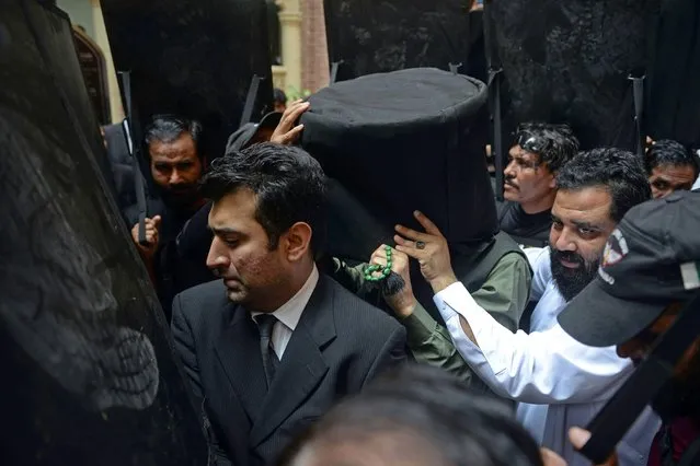 Security personnel with ballistic shields escort former Pakistan's prime minister Imran Khan (C) to the High Court in Lahore on May 30, 2023. (Photo by Syed Murtaza/AFP Photo)