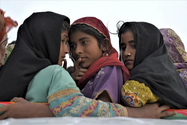 Girls travel in a vehicle as they evacuate with their families due to Cyclone Biparjoy approaching, at a costal area Golarchi in Badin district, in Pakistan's Sindh province, Tuesday, June 13, 2023. (Photo by Umair Rajput/AP Photo)