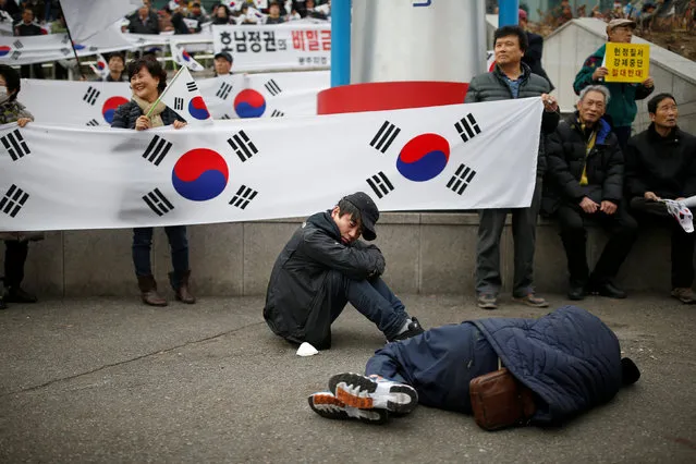 Homeless men nap in front of supporters of South Korean President Park Geun-hye during a rally opposing calls for her resignation, in Seoul, South Korea, November 19, 2016. (Photo by Kim Hong-Ji/Reuters)