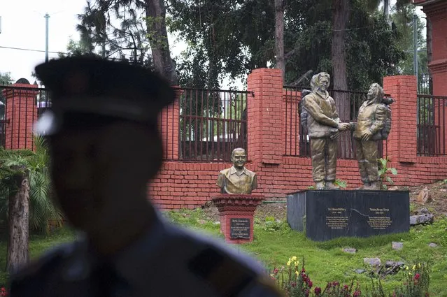 A security person stands guard in front of a statue of Tenzing Norgay and Edmund Hillary at the tourism board in Kathmandu, Nepal, Thursday, May 25, 2023. Nepal is getting ready to mark the 70th anniversary of the first ascent of Mount Everest in 1953 by New Zealander Edmund Hillary and his Sherpa guide Tenzing Norgay. (Photo by Niranjan Shrestha/AP Photo)