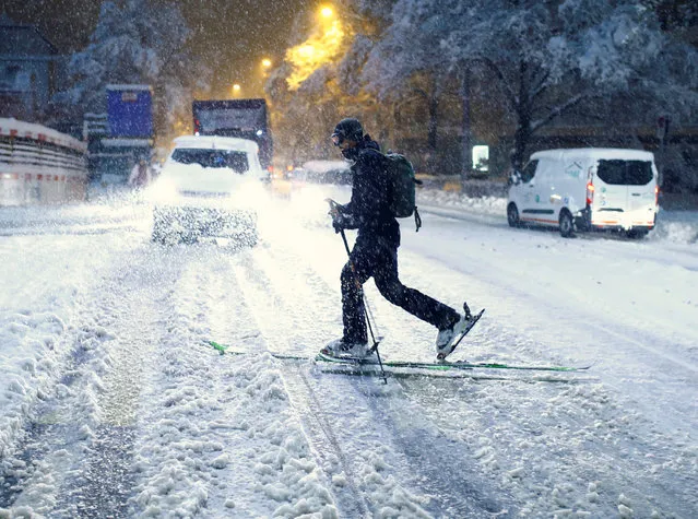 A man on skiis crosses a street during a heavy snowfall, as the spread of the coronavirus disease (COVID-19) continues, in Zurich, Switzerland on January 15, 2021. (Photo by Arnd Wiegmann/Reuters)