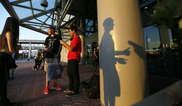 The  shadow of James "Clayster" Eubanks, 22, one of the top ranked gamers in the world, falls on a post as he talks to a reporter during a break outside the Major League Gaming World Finals in New Orleans, Friday, October 16, 2015. (Photo by Gerald Herbert/AP Photo)