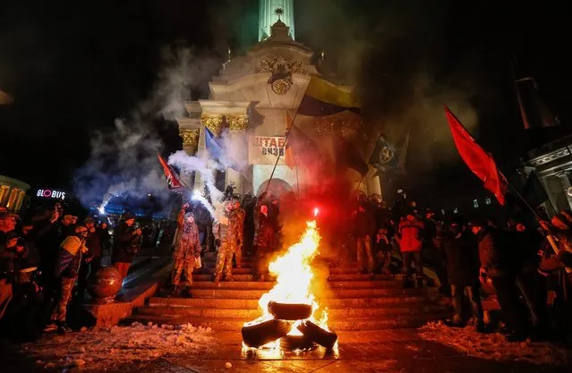 Activists and supporters of Ukrainian nationalist groups burn tires during a rally to mark the third anniversary of the Euromaidan Revolution on the Independence Square in Kiev, Ukraine, 21 November 2016. About one thousand activists took park in the rally during which they burned tires on the Independence Square, destroyed the Russian bank Sberbank and broke windows in the office of a Ukrainian politician Viktor Medvedchuk, according to Ukrainian media. On 21 November 2013 activists started an anti-government picket after then-Prime Minister Mykola Azarov announced the suspension of a landmark treaty with the European Union. The protests eventually led to the ouster of President Viktor Yanukovych, creating political rifts through the country that erupted into a violent conflict between seperatists and government forces in the eastern part of the country in the spring. (Photo by Roman Pilipey/EPA)